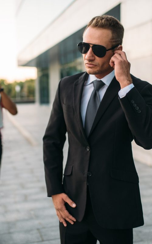 bodyguard-in-sunglasses-and-black-business-woman.jpg